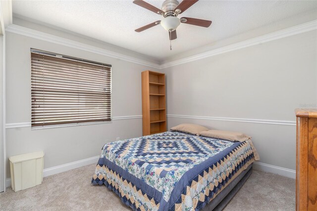 carpeted bedroom featuring crown molding and ceiling fan