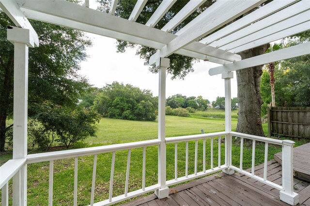 wooden deck featuring a pergola and a lawn