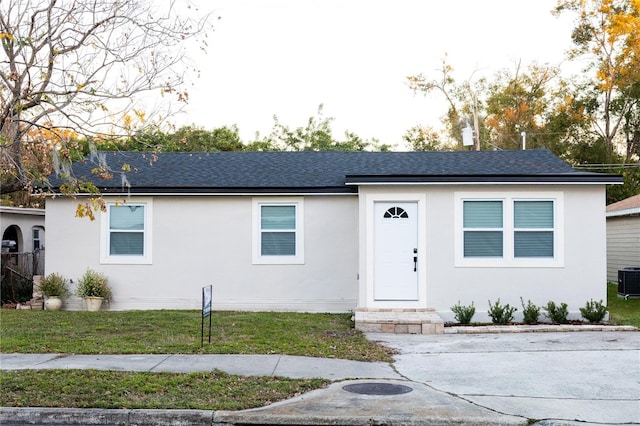 view of front of house featuring central AC unit and a front yard