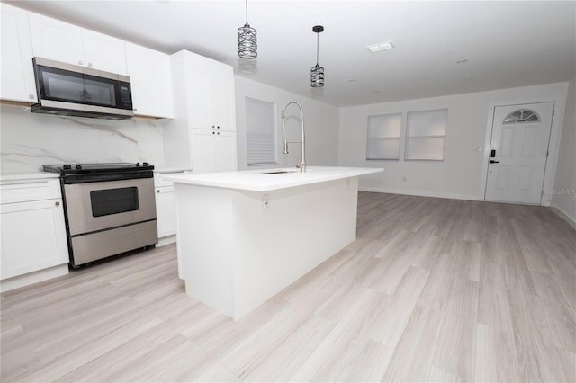 kitchen featuring light hardwood / wood-style flooring, stainless steel appliances, sink, an island with sink, and white cabinetry