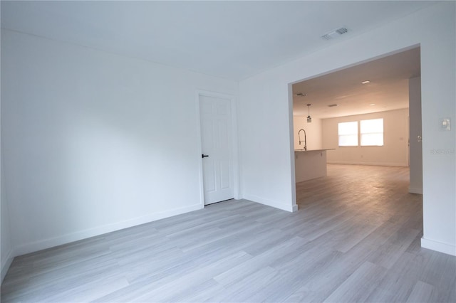 spare room with sink and hardwood / wood-style flooring