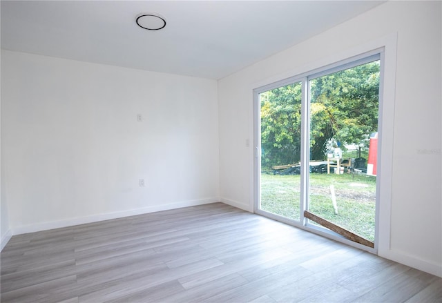 spare room featuring wood-type flooring and a healthy amount of sunlight