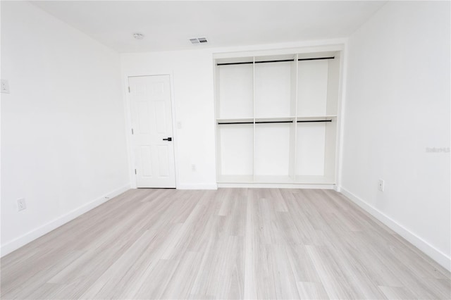 unfurnished bedroom with light wood-type flooring and a closet