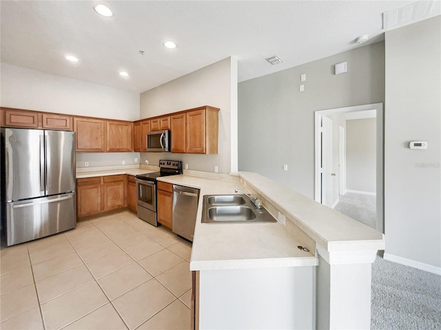 kitchen with sink, appliances with stainless steel finishes, kitchen peninsula, and light colored carpet