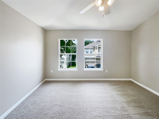 carpeted spare room with ceiling fan