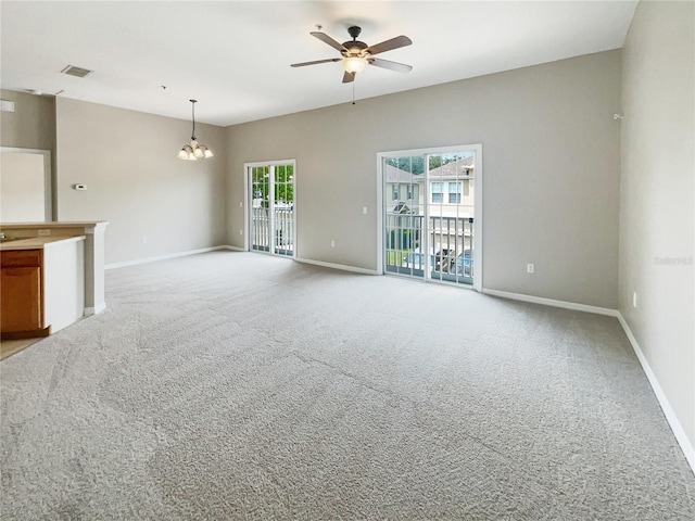 unfurnished living room featuring light colored carpet and ceiling fan with notable chandelier