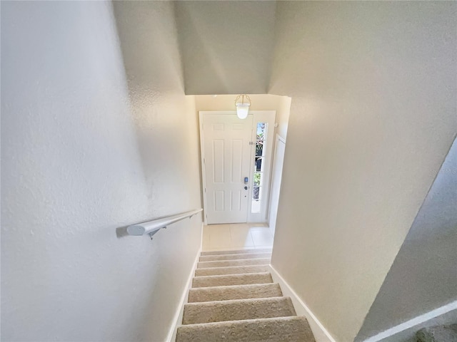 stairway featuring tile patterned flooring