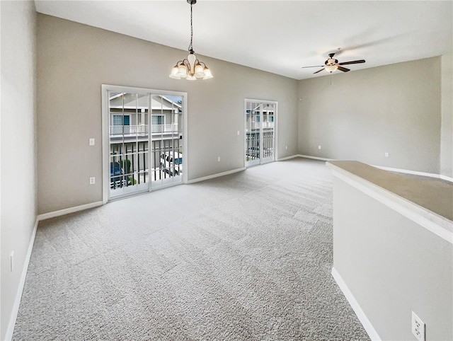 carpeted empty room with ceiling fan with notable chandelier