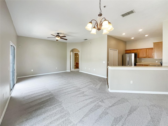 unfurnished living room with light carpet and ceiling fan with notable chandelier