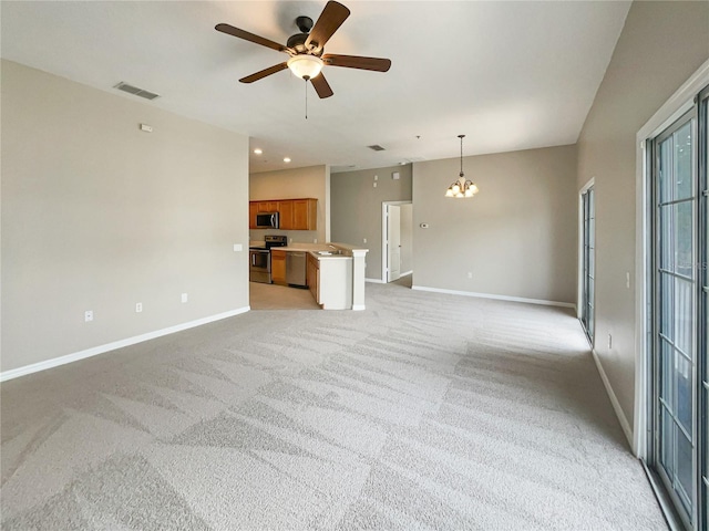 unfurnished living room with sink, ceiling fan with notable chandelier, and light colored carpet