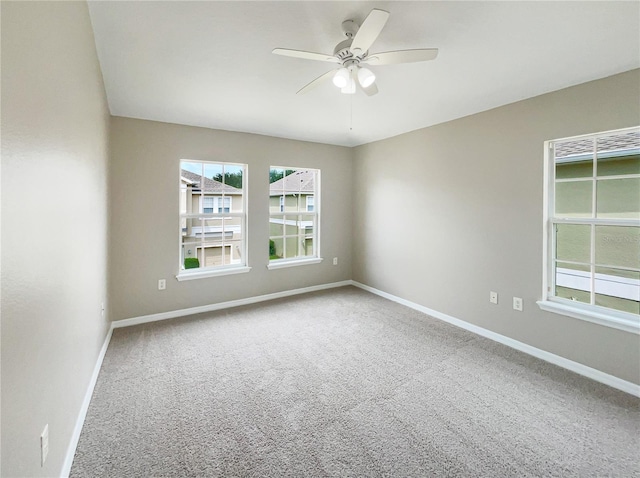 carpeted spare room featuring ceiling fan