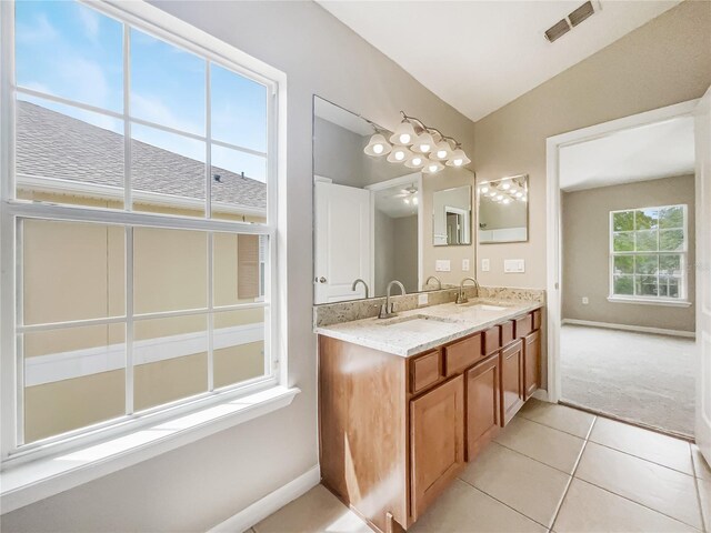 bathroom with vaulted ceiling, tile patterned flooring, and double sink vanity