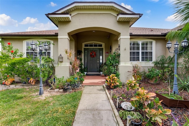 view of exterior entry featuring a lawn