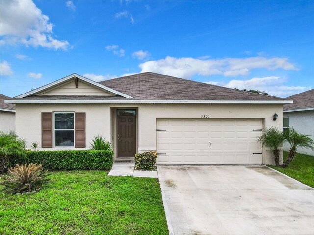 single story home with a garage and a front lawn