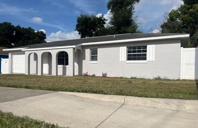 single story home featuring a garage and a front yard