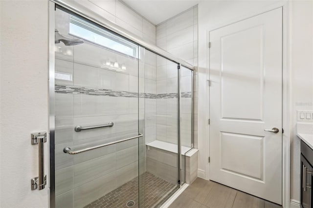 bathroom featuring walk in shower, vanity, and tile patterned flooring