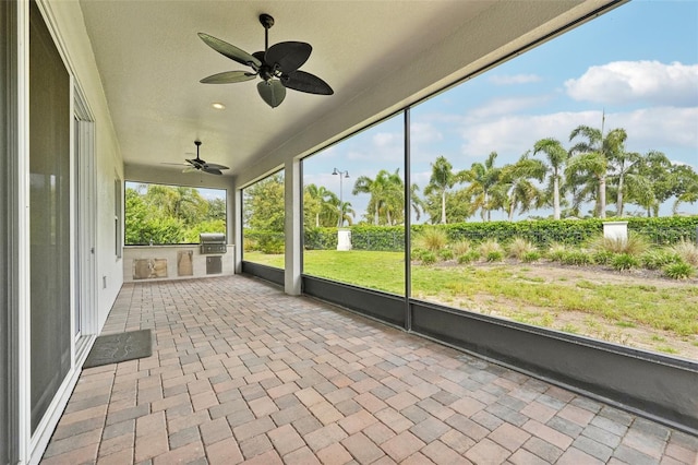 unfurnished sunroom featuring ceiling fan