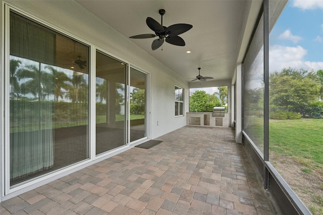 unfurnished sunroom with ceiling fan