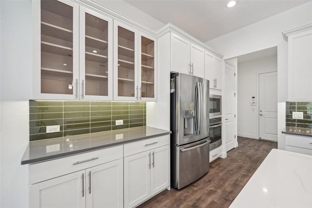 kitchen featuring white cabinetry, stainless steel appliances, dark hardwood / wood-style floors, and decorative backsplash