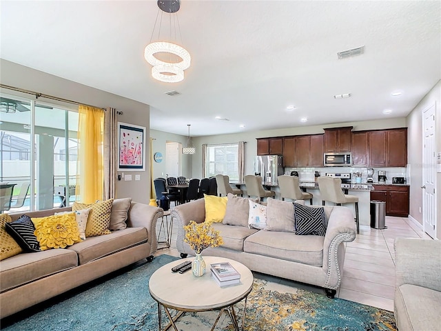 living room with a chandelier and light tile patterned floors