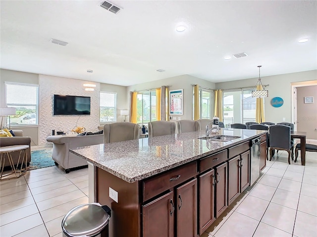 kitchen with sink, pendant lighting, light tile patterned floors, and light stone countertops