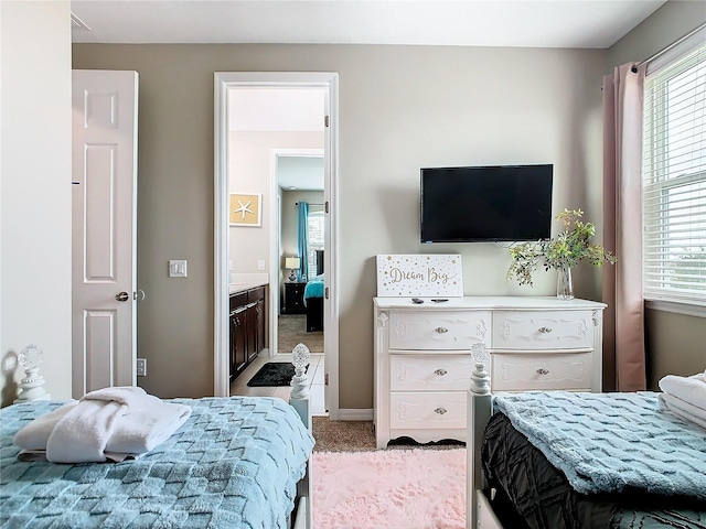 bedroom featuring light colored carpet and multiple windows