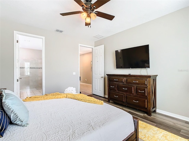 bedroom featuring connected bathroom, hardwood / wood-style floors, and ceiling fan