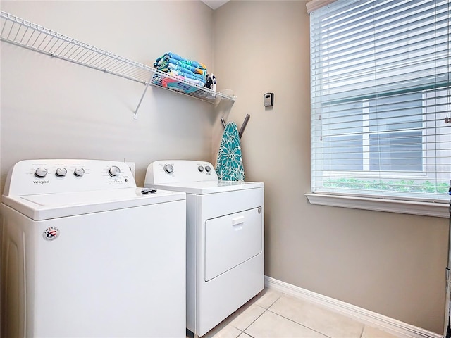 laundry room featuring separate washer and dryer and light tile patterned floors