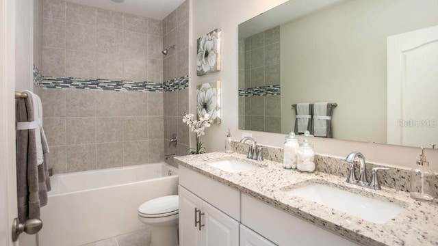 full bathroom featuring dual vanity, tile patterned flooring, tiled shower / bath combo, and toilet