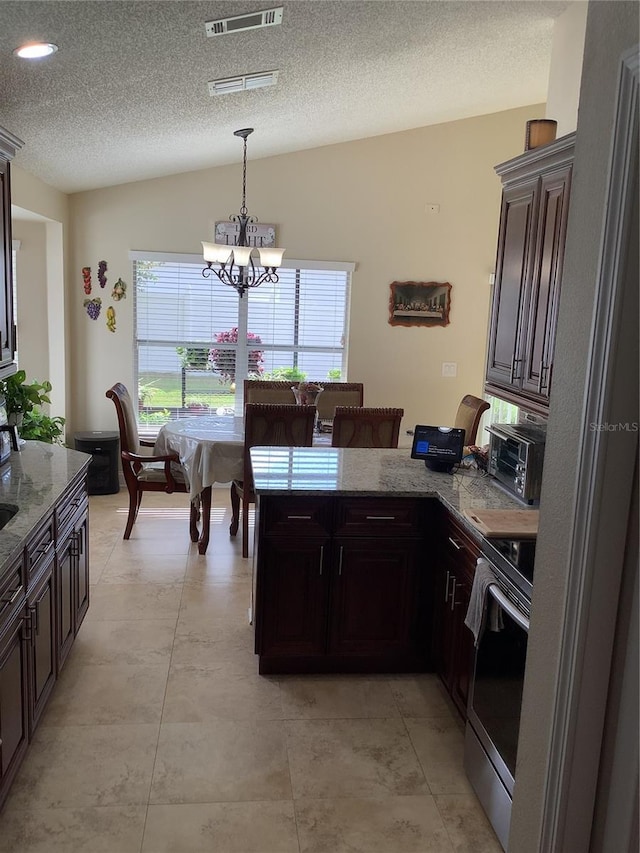 kitchen featuring stainless steel electric stove, lofted ceiling, dark brown cabinets, and a notable chandelier