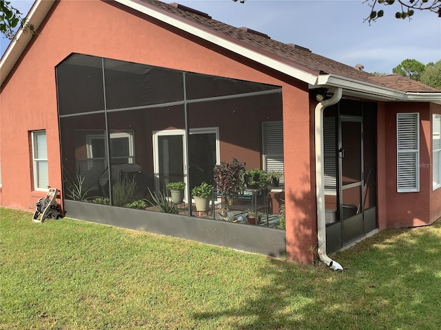 view of side of property featuring a sunroom and a yard