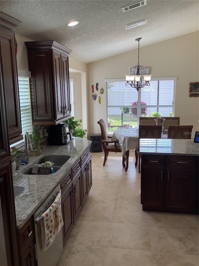 kitchen featuring sink, a chandelier, vaulted ceiling, stainless steel dishwasher, and pendant lighting