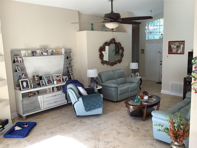 living room featuring ceiling fan and a high ceiling