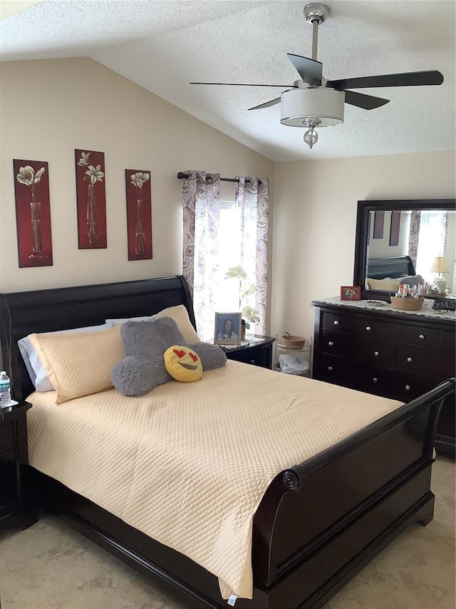 bedroom with ceiling fan, lofted ceiling, and a textured ceiling