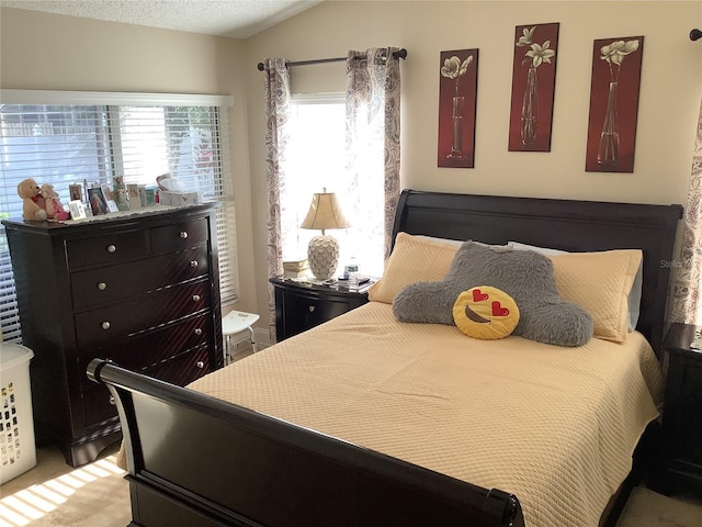 bedroom featuring vaulted ceiling and a textured ceiling