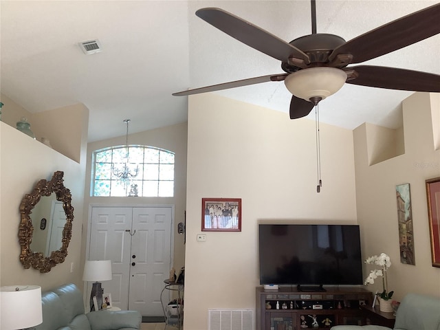 foyer entrance with vaulted ceiling and ceiling fan with notable chandelier