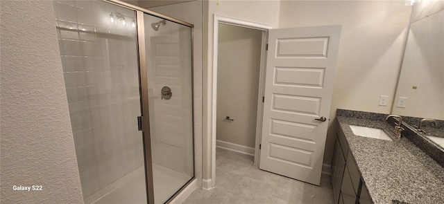 full bath featuring a shower stall, baseboards, and vanity