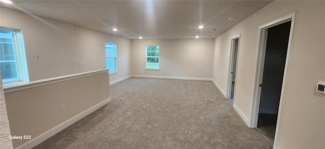 spare room with recessed lighting, light colored carpet, and baseboards