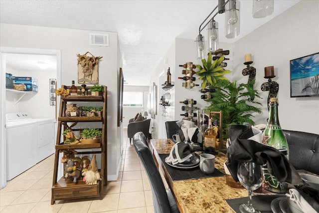 kitchen with a textured ceiling, washer and dryer, and light tile patterned floors