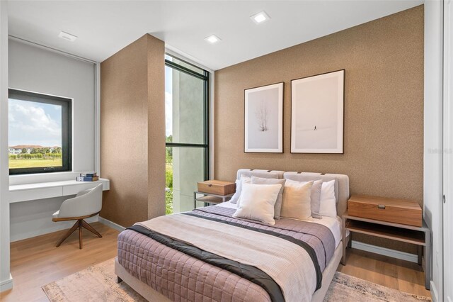 bedroom with built in desk and light hardwood / wood-style flooring