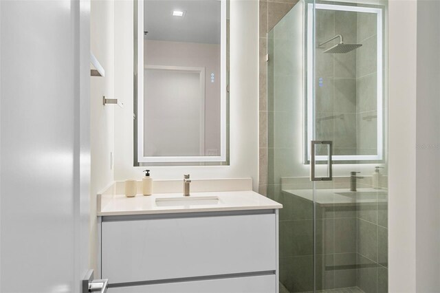 bathroom featuring walk in shower and vanity