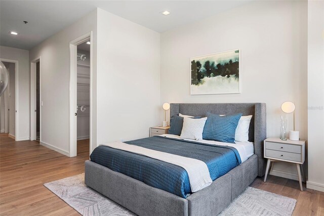 bedroom with a closet, a spacious closet, and hardwood / wood-style flooring