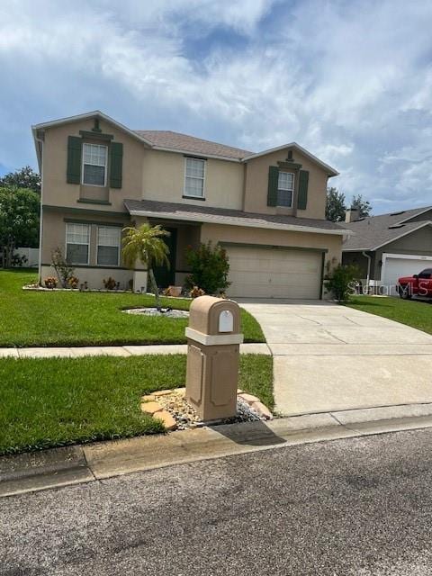 traditional-style house with driveway, a front lawn, an attached garage, and stucco siding