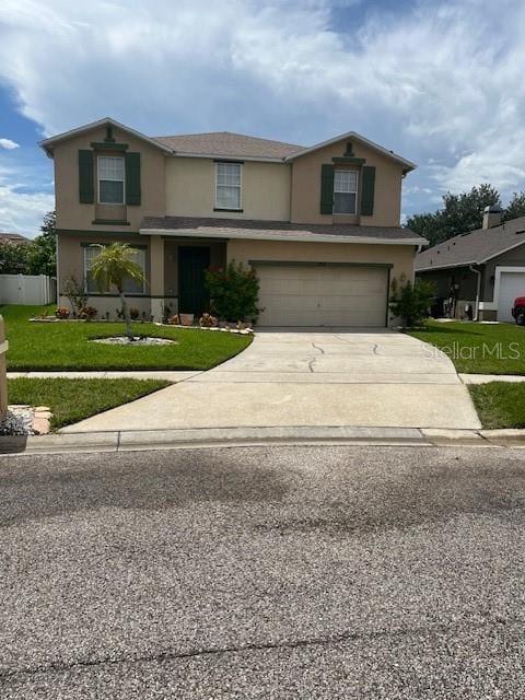 traditional-style home featuring driveway, stucco siding, an attached garage, and a front yard