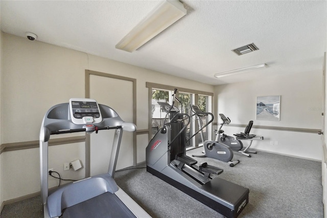 workout room featuring carpet and a textured ceiling