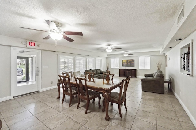 tiled dining area with ceiling fan and a textured ceiling