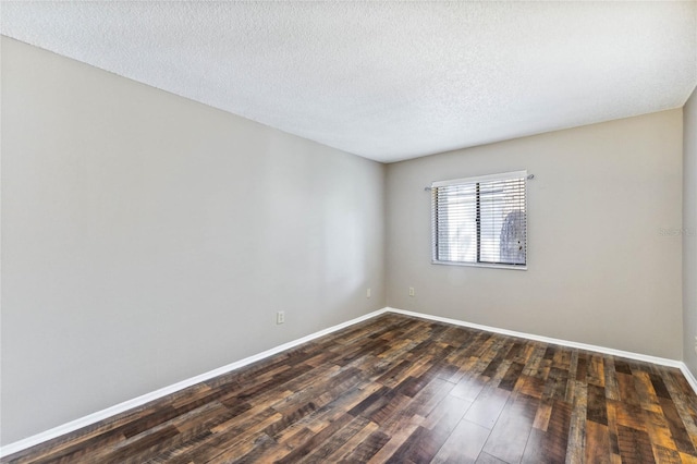 empty room featuring a textured ceiling and dark hardwood / wood-style flooring