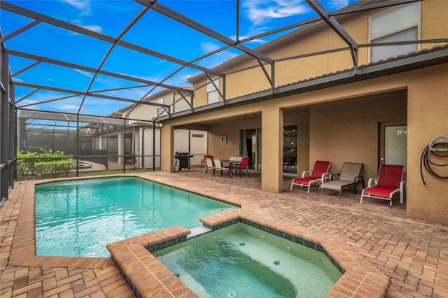 view of swimming pool featuring area for grilling, a patio area, a lanai, and a pool with connected hot tub