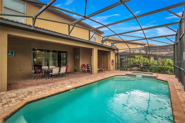 view of pool featuring an in ground hot tub, a patio, and glass enclosure