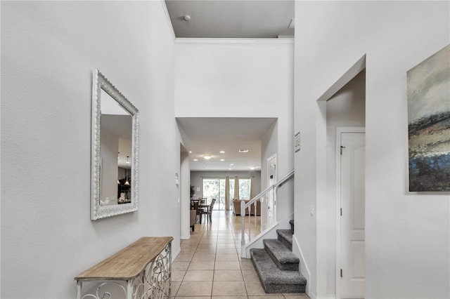 hallway featuring light tile patterned floors and a high ceiling